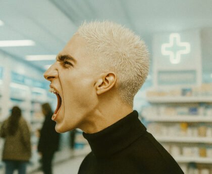 Persoon schreeuwt luid in een winkelomgeving als uitdrukking van frustratie of protest